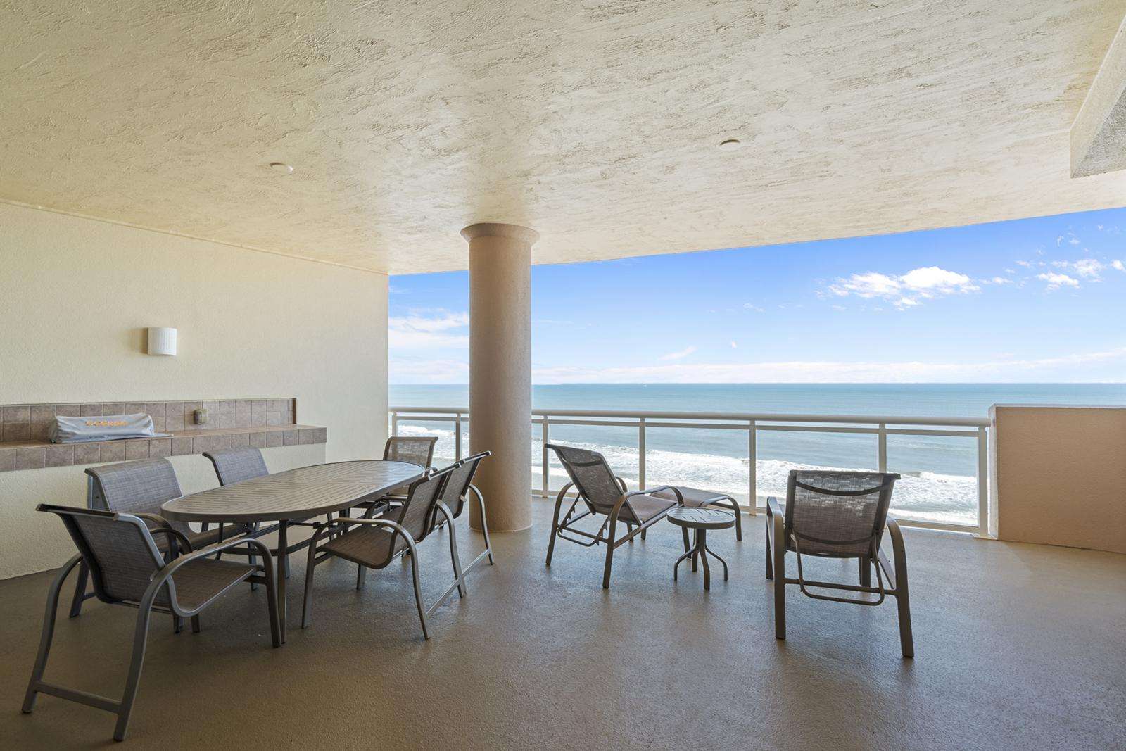 Spacious oceanfront patio with panoramic sea views and dining area - property