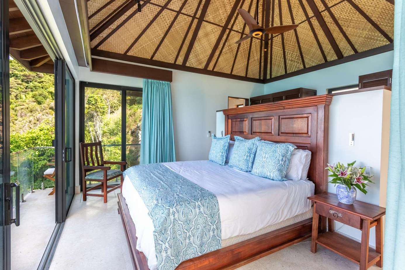 Serene bedroom with tropical views and cozy outdoor seating