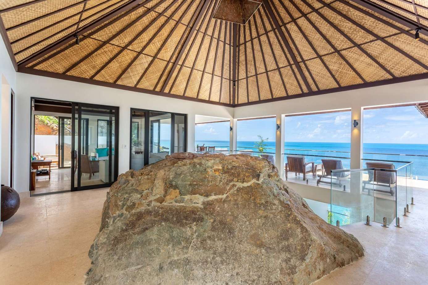 Oceanfront patio with natural rock centerpiece and panoramic views