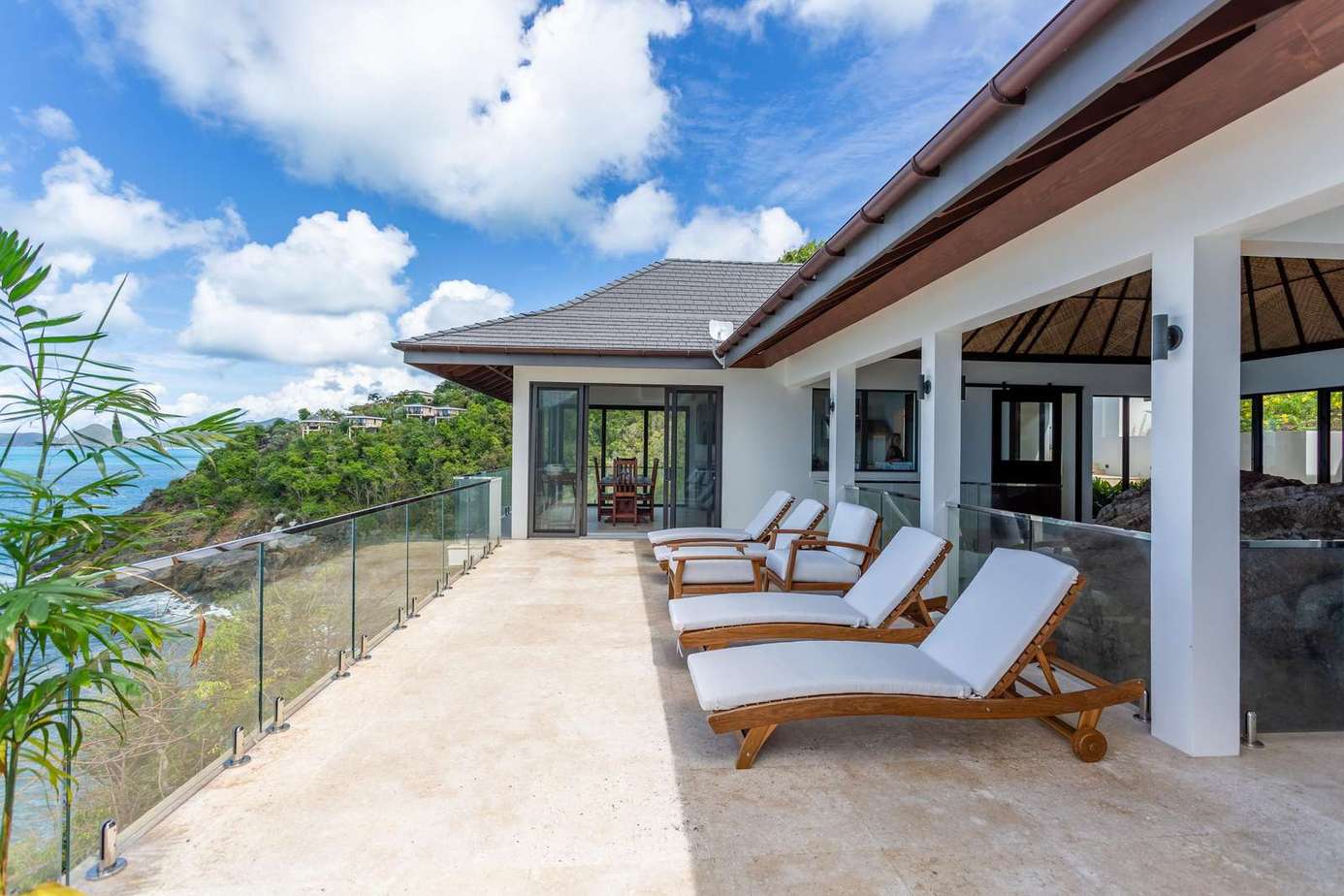 Sun-drenched patio with panoramic sky views and lounge chairs