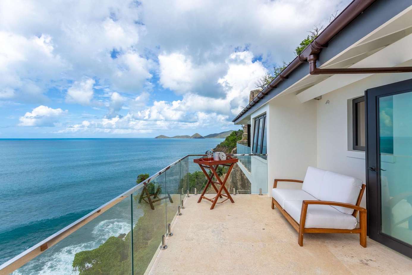 Oceanfront balcony with panoramic sea views and cozy seating