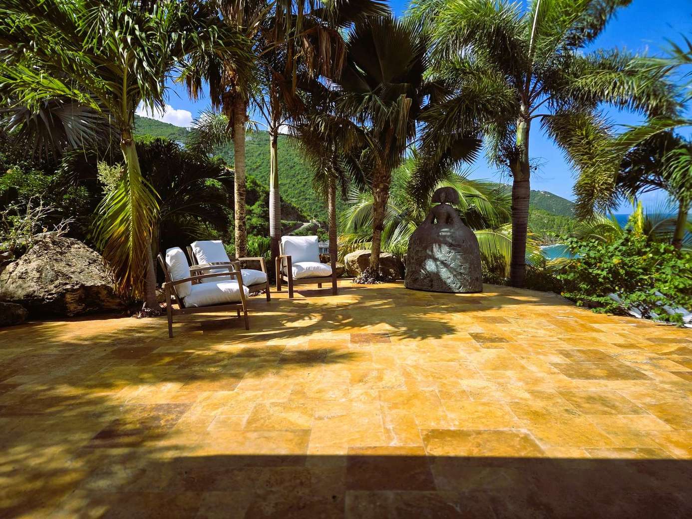 Secluded tropical patio with lush palm shade and cozy seating