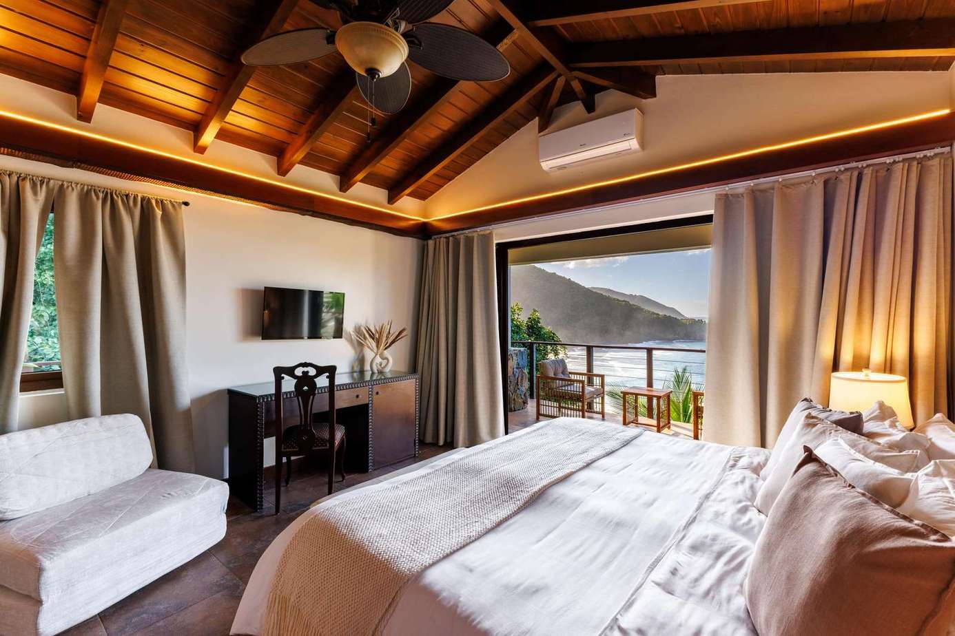 Cozy bedroom retreat with vaulted ceilings and scenic balcony views