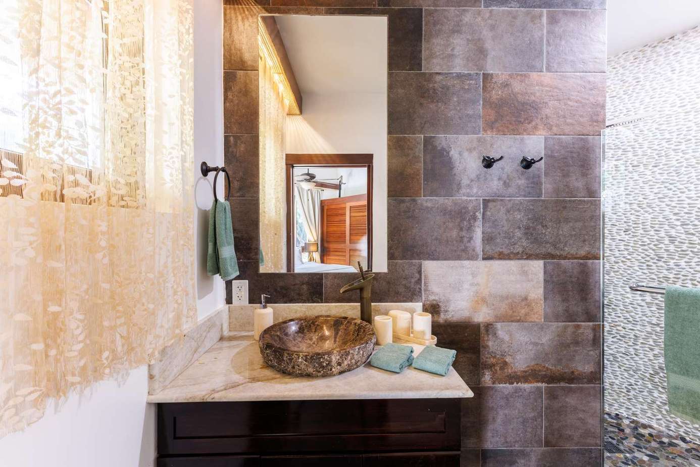 Spa-inspired bathroom with rustic stone walls and elegant vessel sink