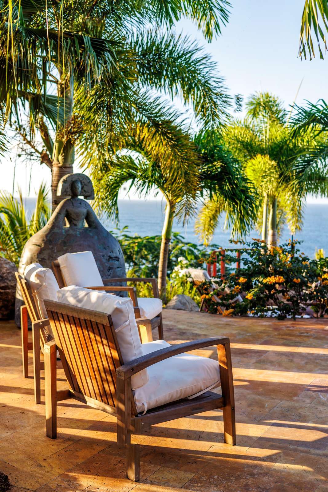 Sunlit patio retreat with cozy seating and tropical views