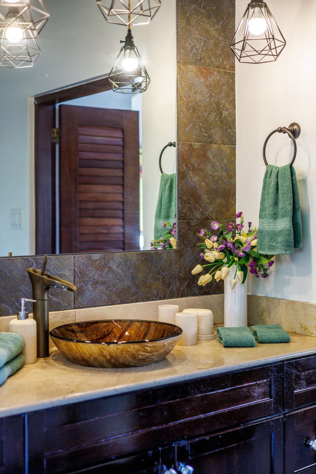 Elegant bathroom with rustic vessel sink and warm lighting