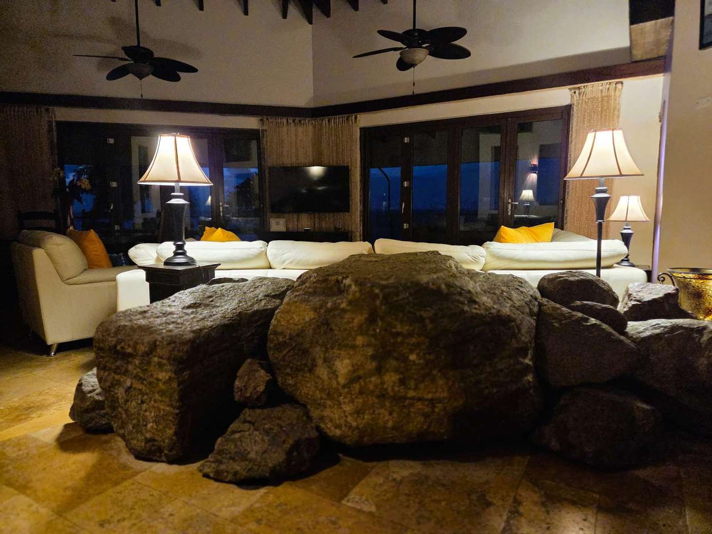 Cozy living room with rustic stone fireplace and warm lighting