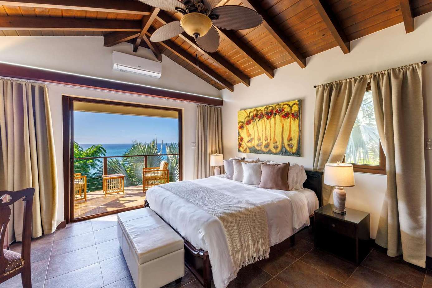 Sunlit bedroom with vaulted ceilings and ocean views