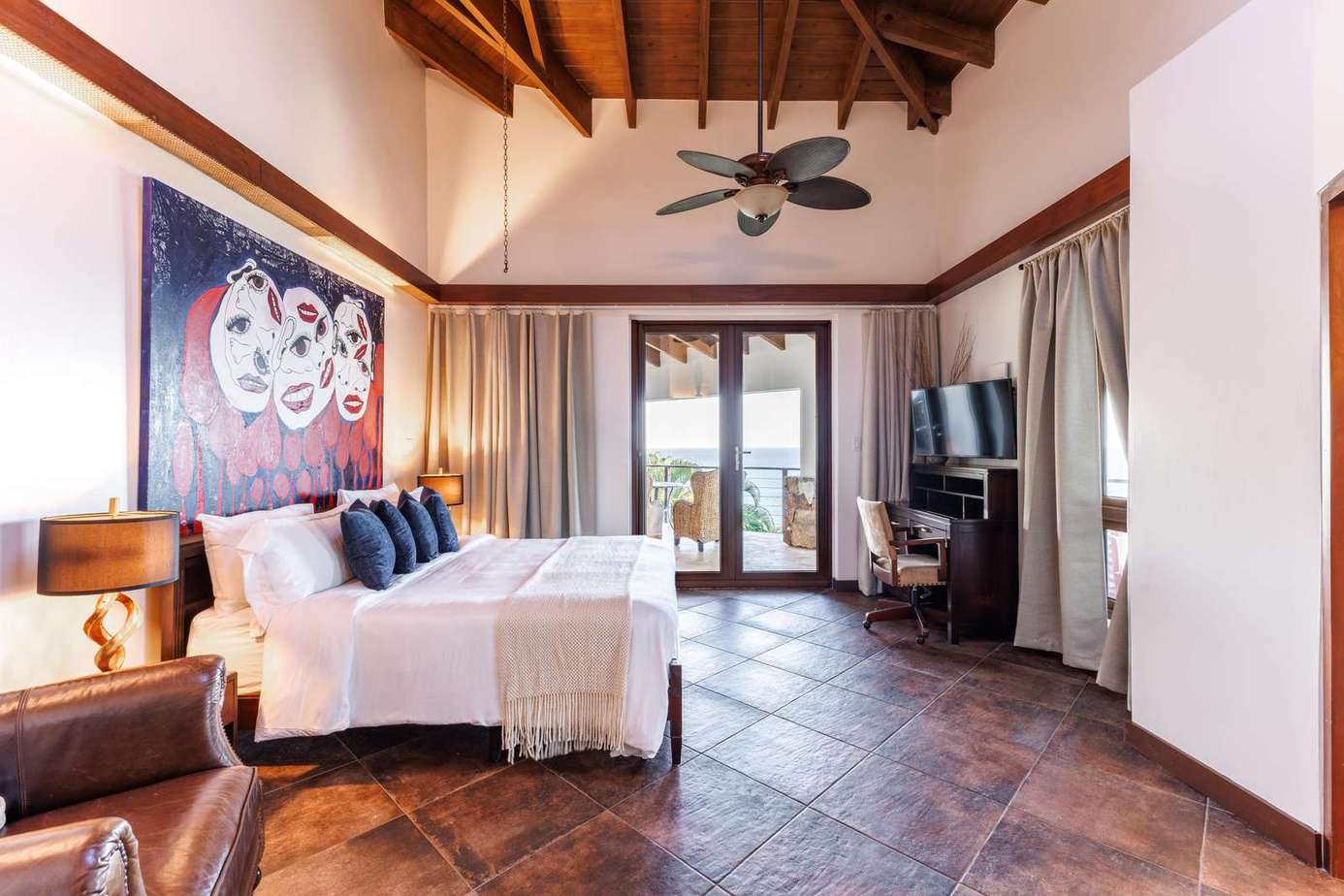 Spacious bedroom with vaulted ceilings and private balcony access