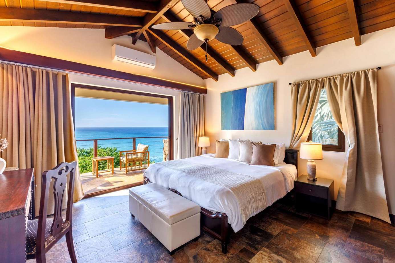 Cozy bedroom with vaulted ceiling and ocean views