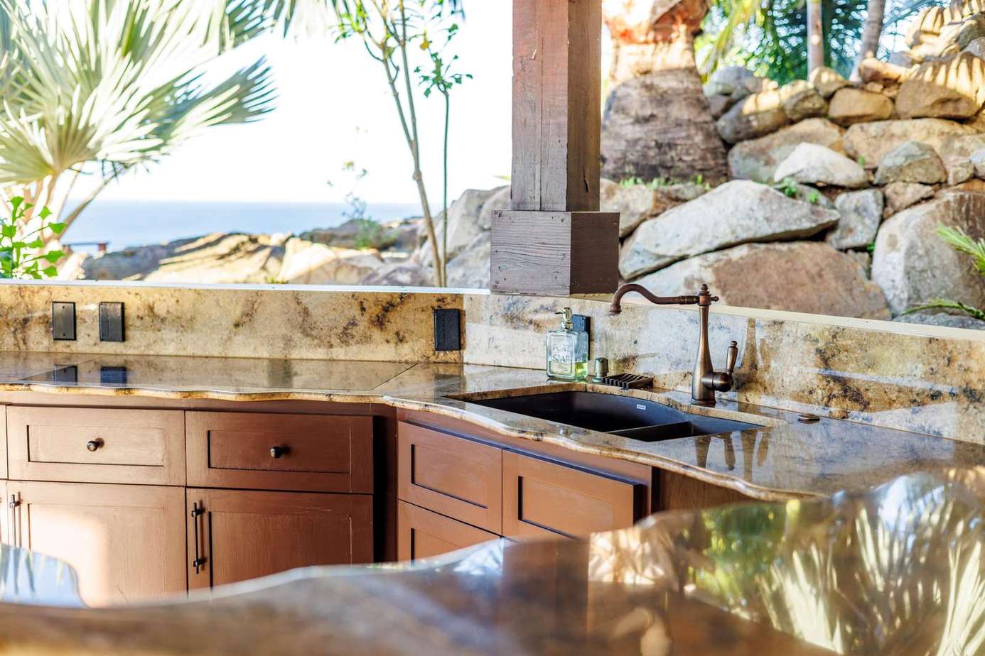 Sunlit kitchen with granite countertops and scenic rock views