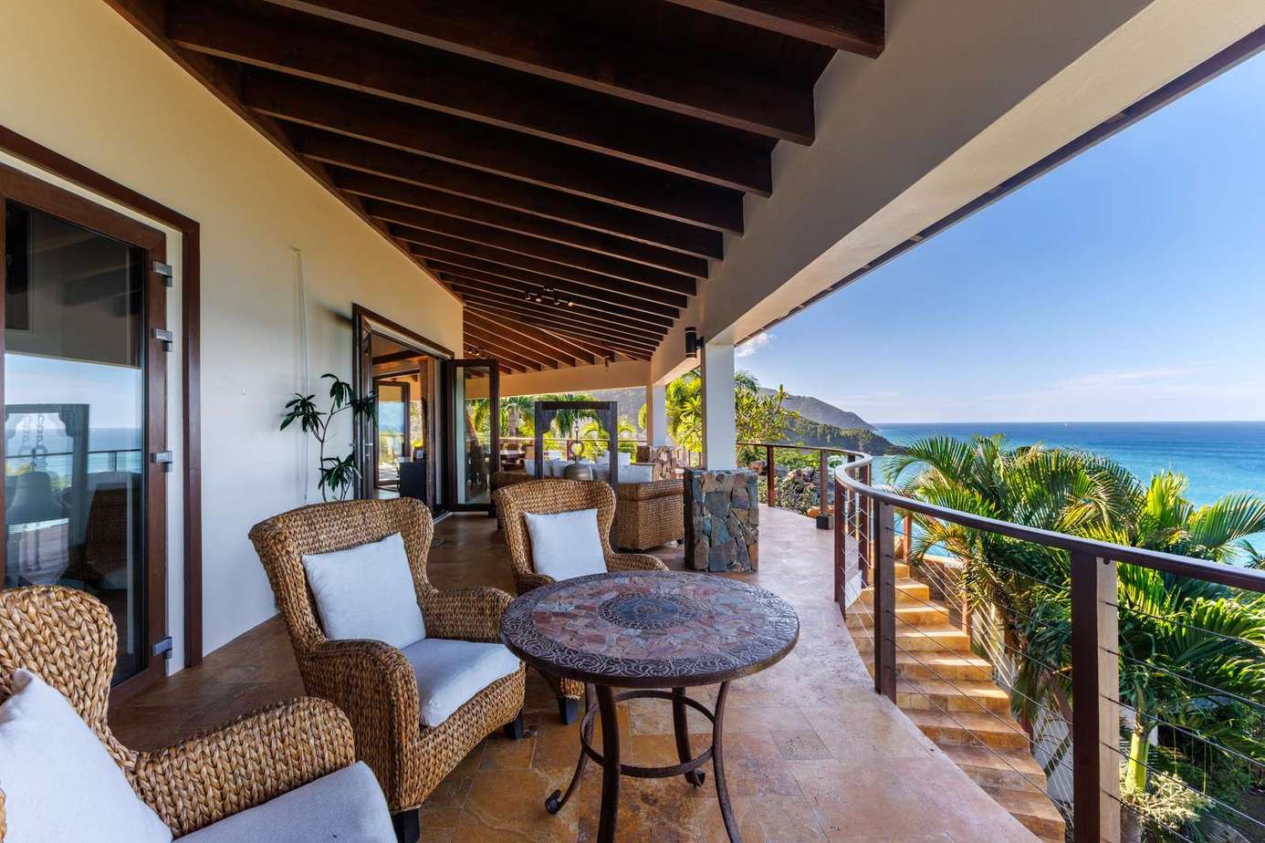 Spacious ocean-view patio with cozy seating for sunset relaxation