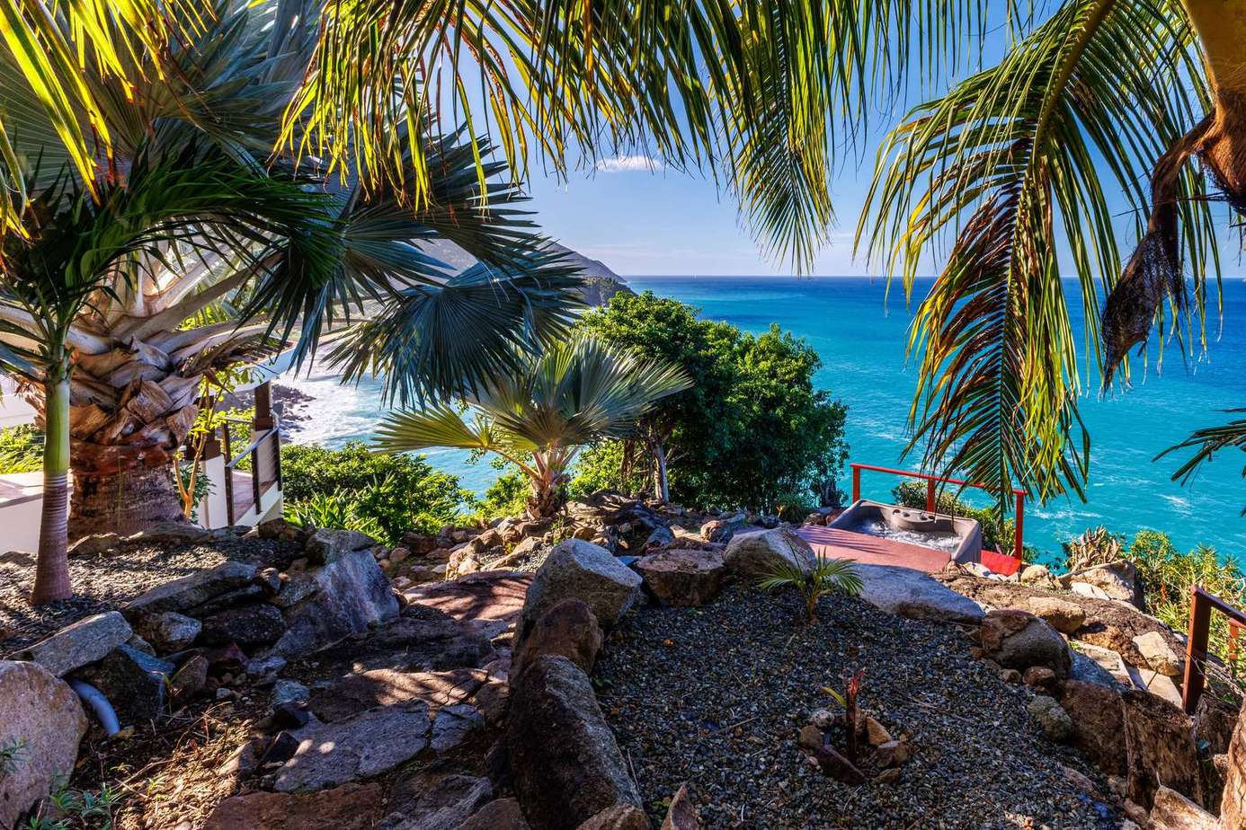 Secluded oceanfront patio framed by swaying palm trees