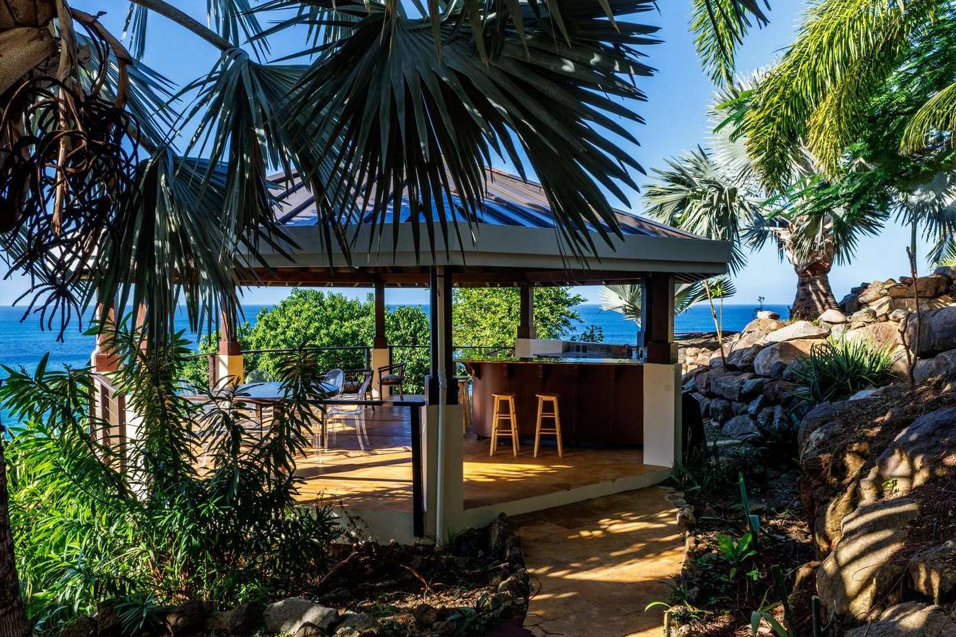 Seaside outdoor bar and lounge surrounded by lush palms