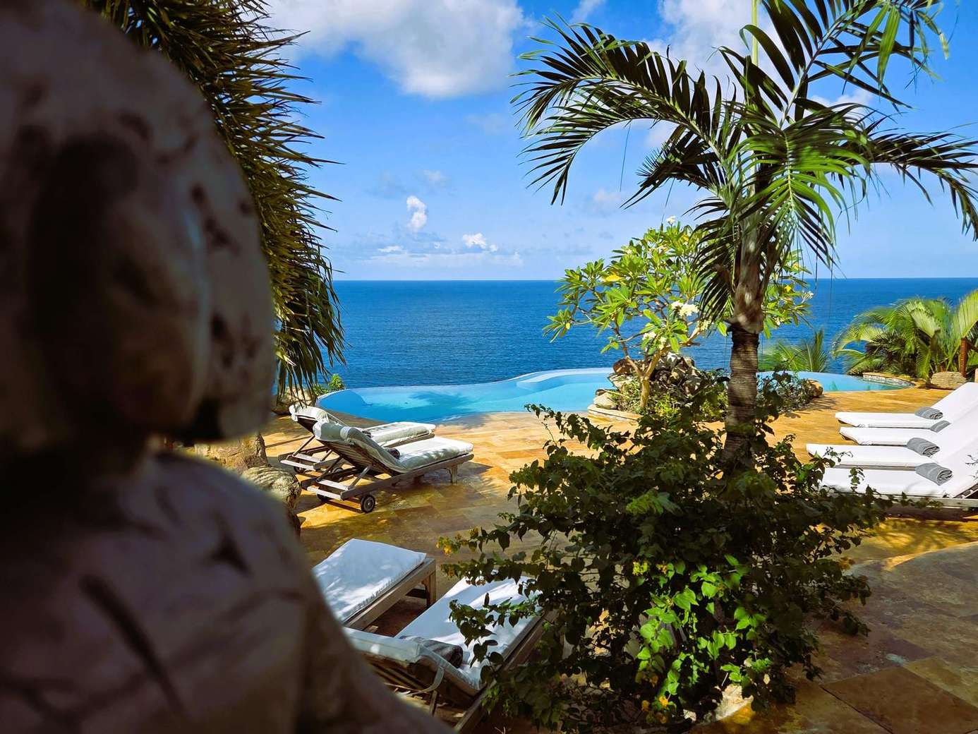 Ocean-view patio with lush tropical surroundings and lounge chairs