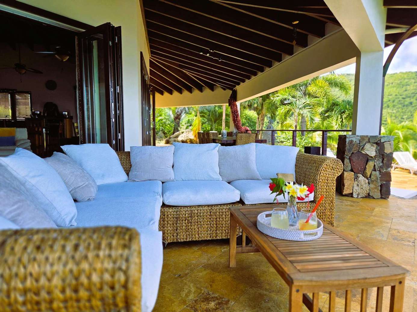 Spacious covered patio with cozy seating and tropical views