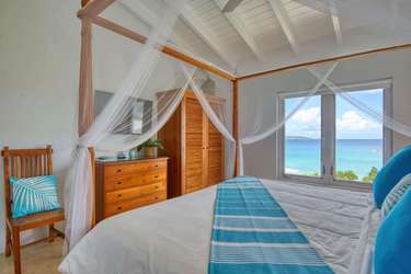 Cozy bedroom with stunning ocean views and vaulted ceilings