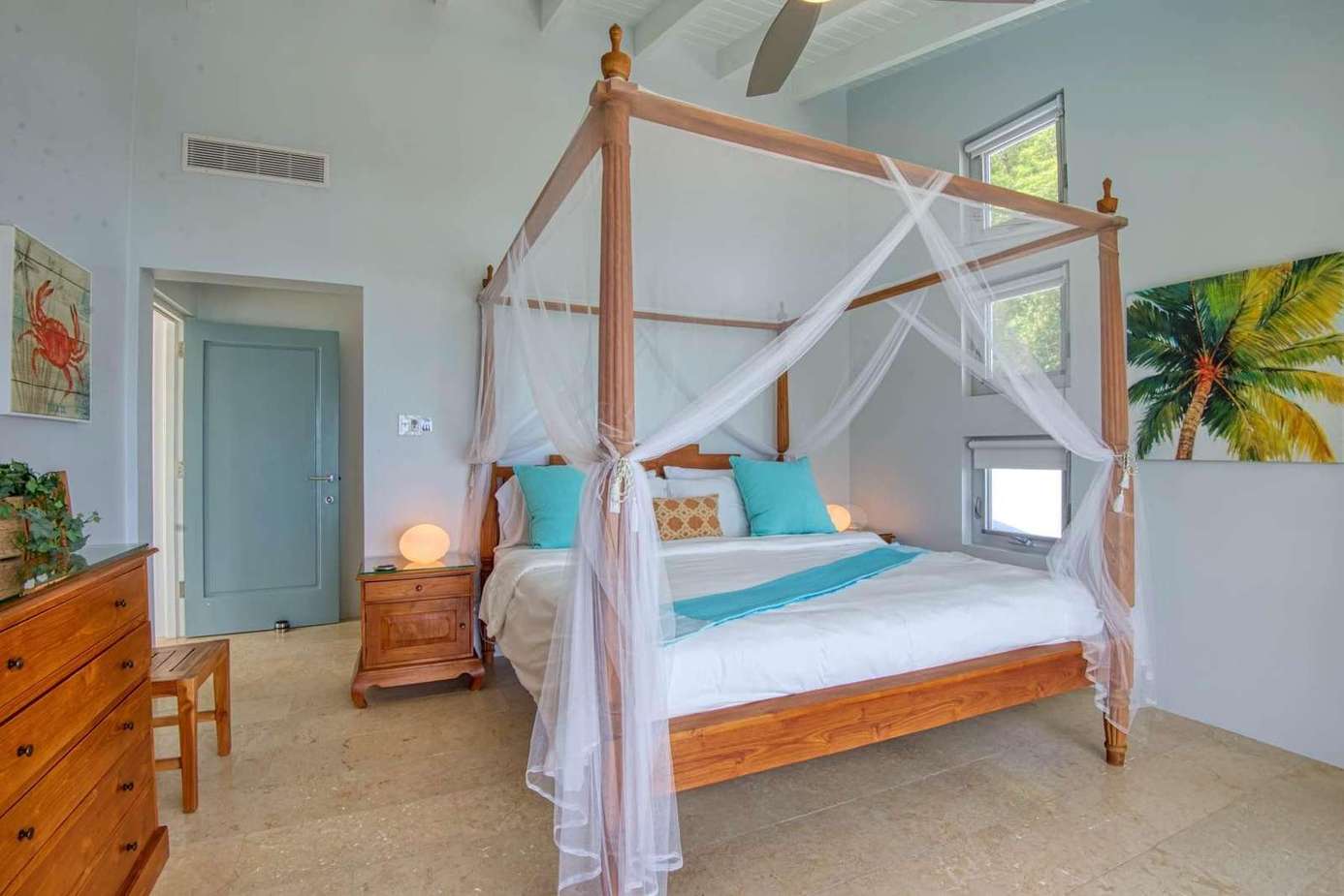 Airy master bedroom with elegant four-poster bed and tropical accents