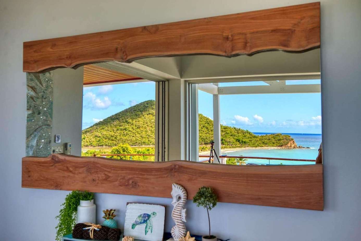 Coastal views framed by rustic wooden mirror in bright living area