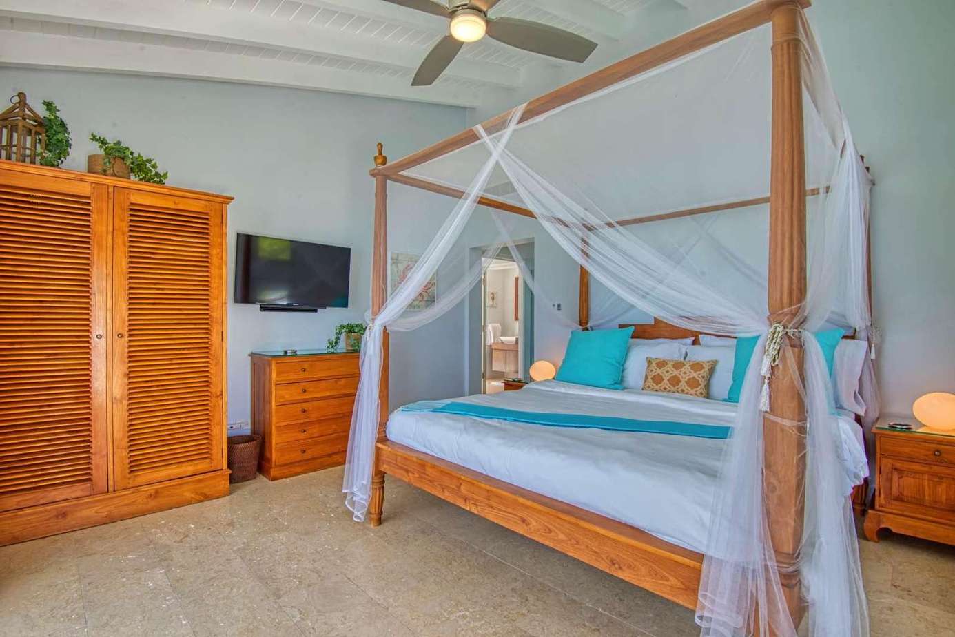 Airy bedroom with canopy bed and cozy tropical accents