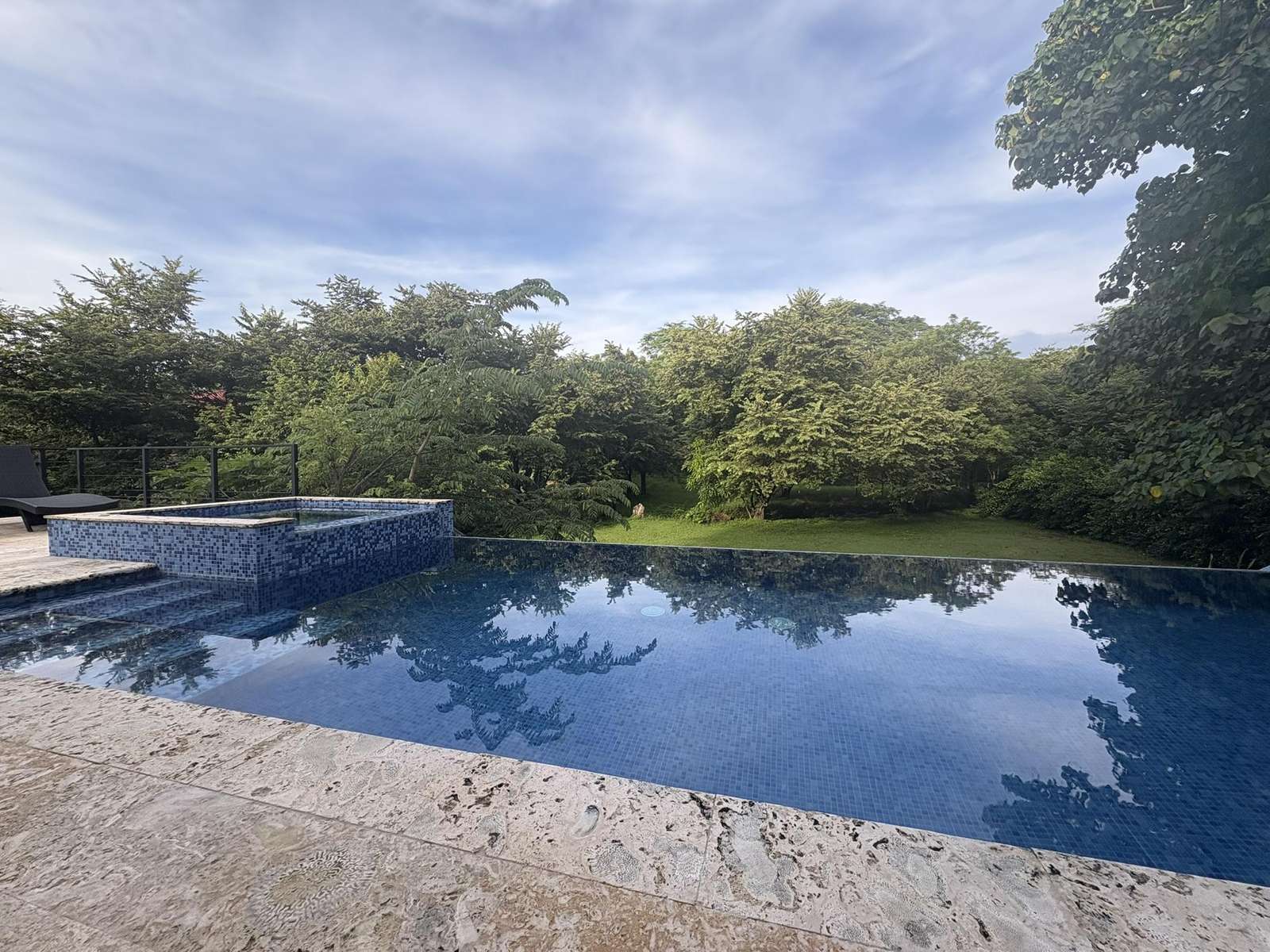 Tranquil infinity pool overlooking lush greenery for ultimate relaxation