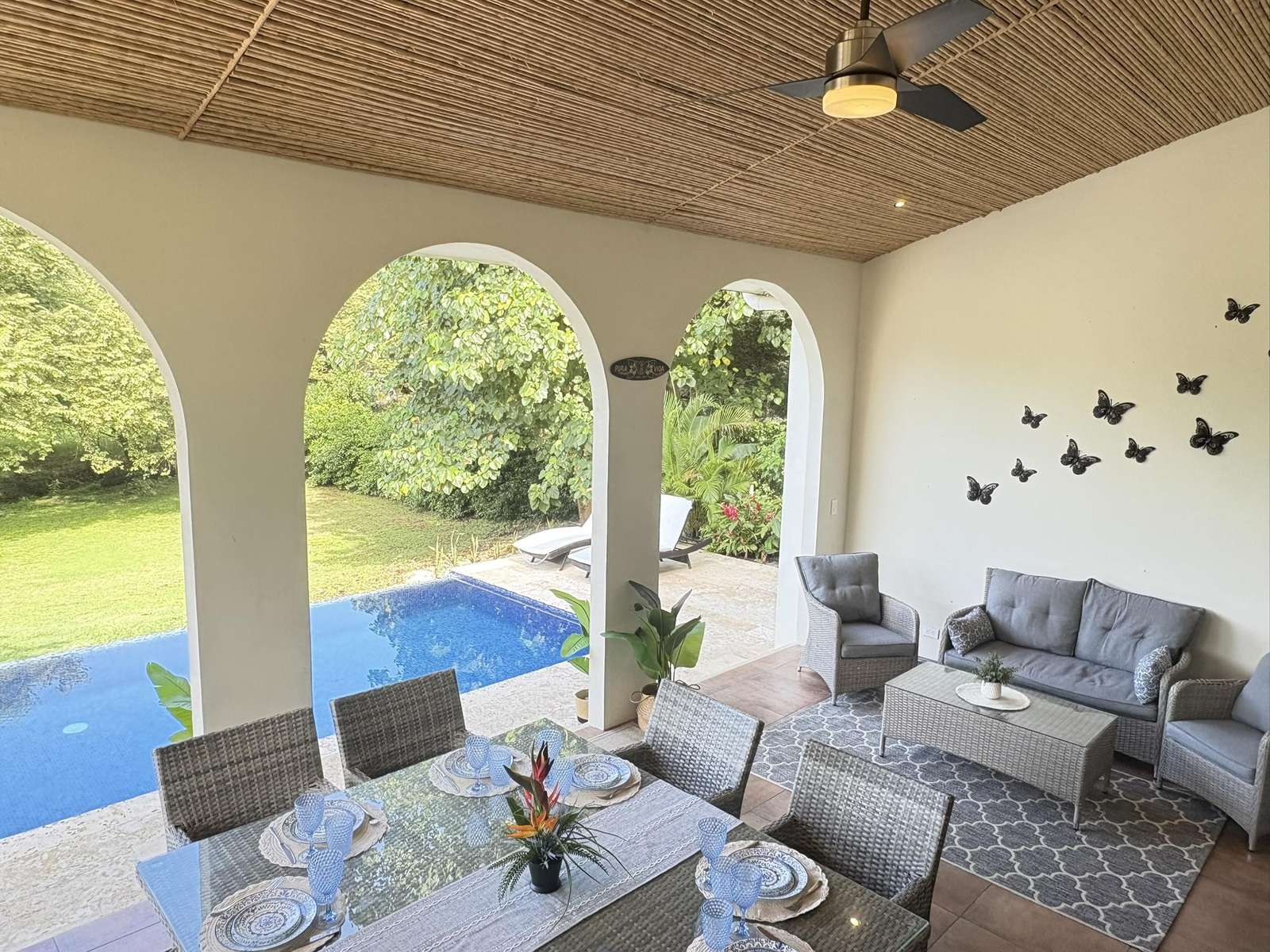 Covered patio with cozy seating and scenic pool views