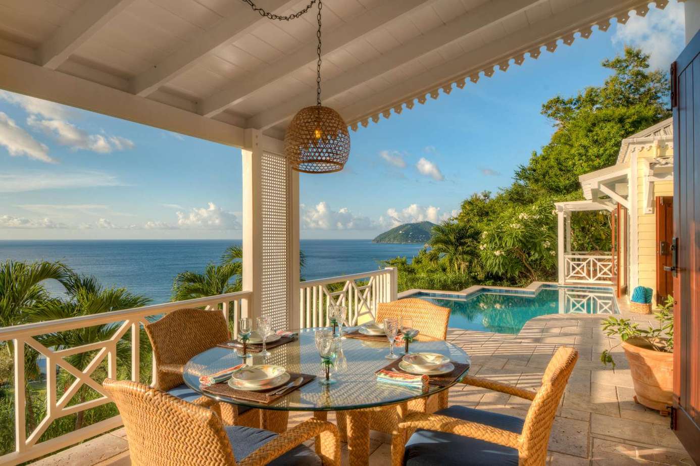 Oceanview dining patio with pool and lush greenery backdrop