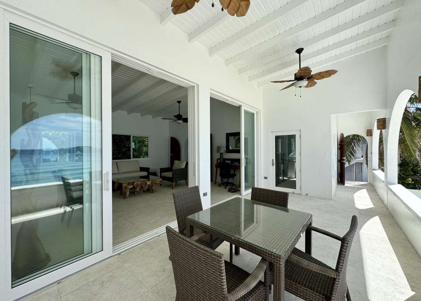 Covered patio with cozy dining and ceiling fans for comfort