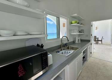 Bright, modern kitchen with ocean views and open shelving