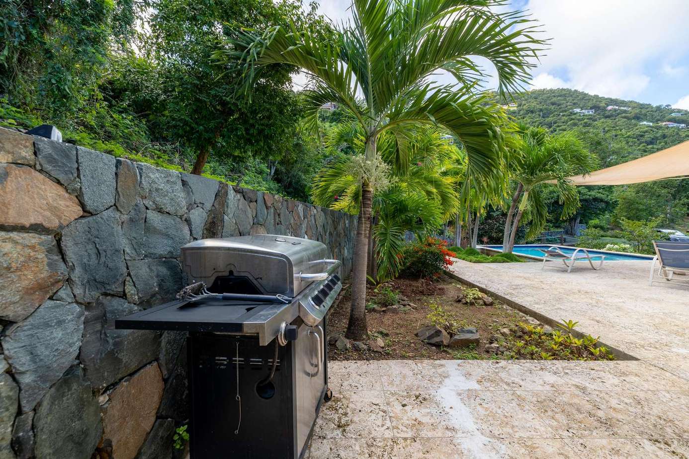 Outdoor grilling area surrounded by lush tropical greenery