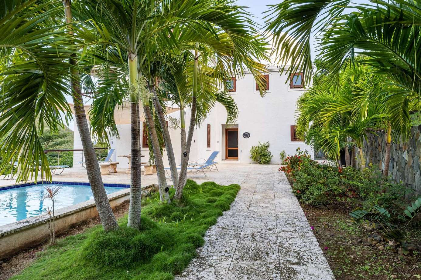 Lush tropical garden path leading to serene poolside retreat