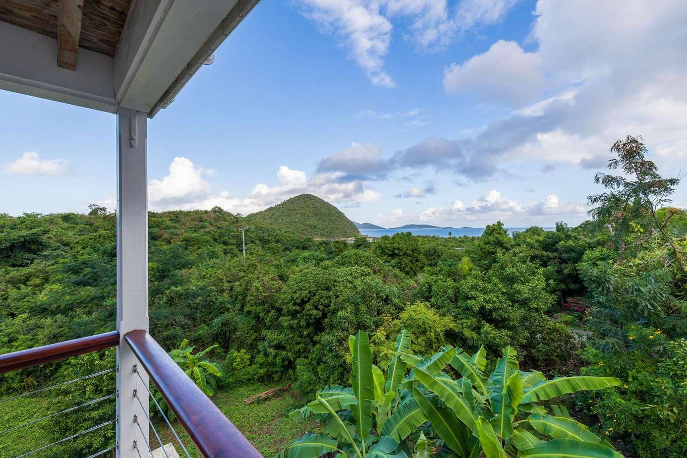 Balcony retreat with lush green mountain views and ocean glimpses