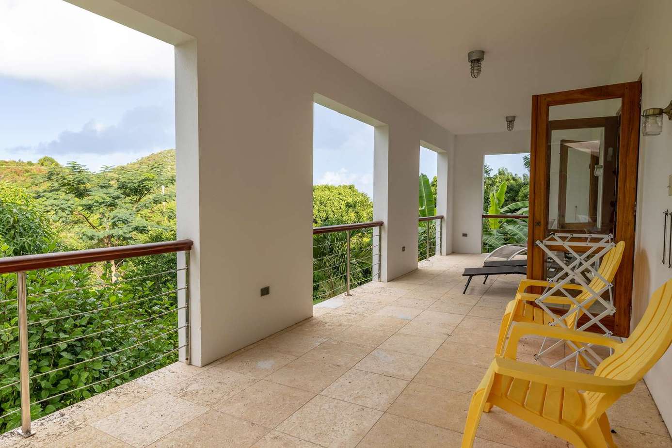 Spacious covered patio with lush garden views and cozy seating