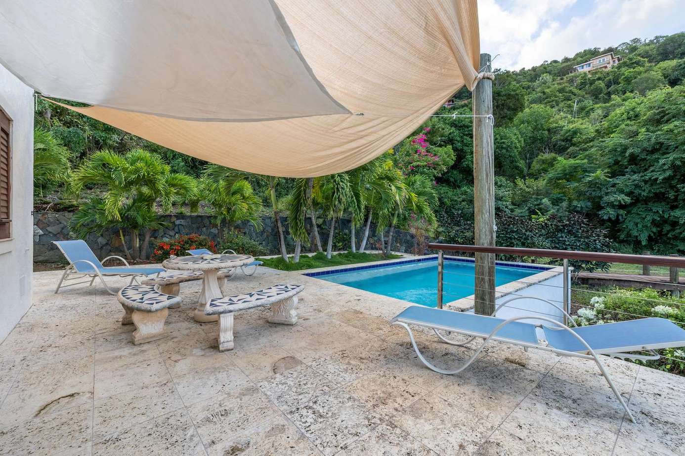 Shaded poolside lounge with lush tropical views