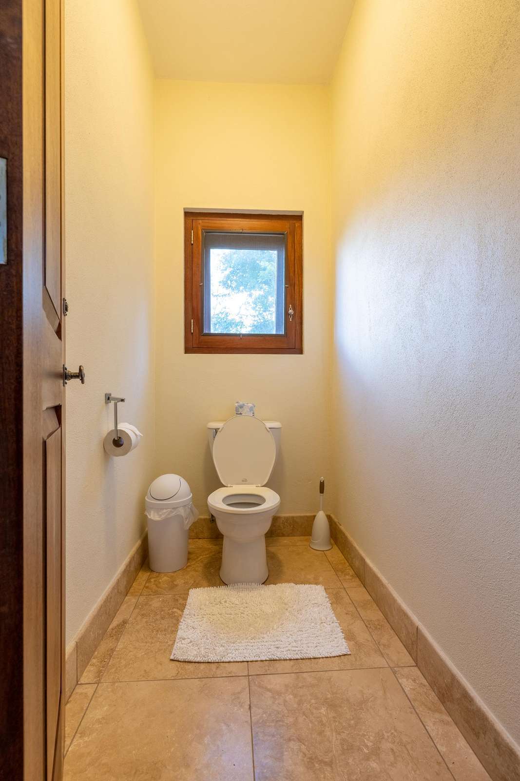 Cozy and bright half-bath with natural light and warm tones