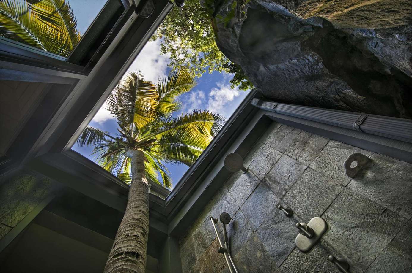 Open-air shower surrounded by lush tropical greenery