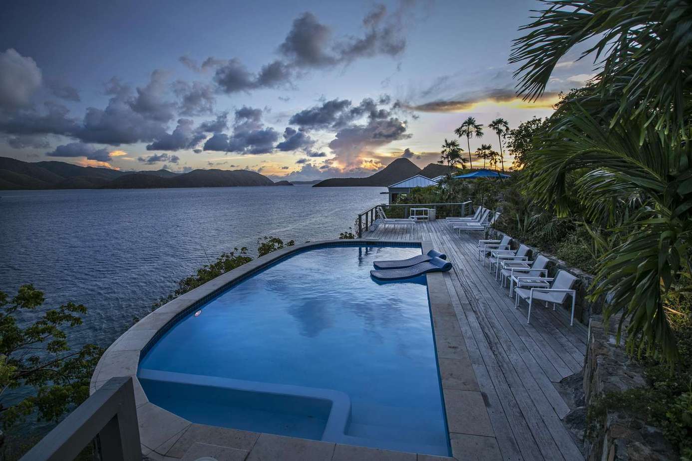 Infinity pool overlooking tranquil ocean at sunset