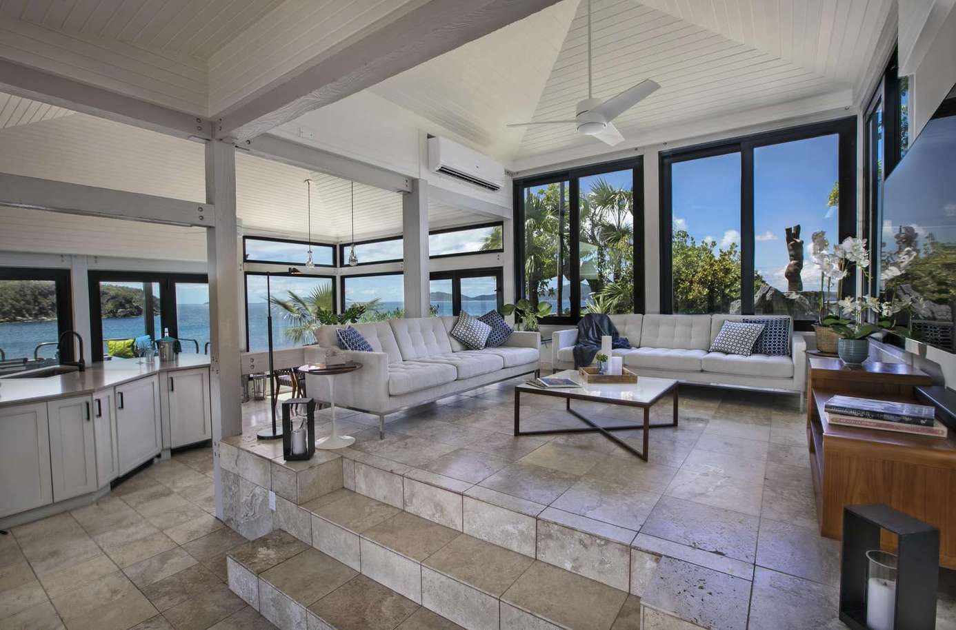 Sunlit living room with panoramic windows and ocean views