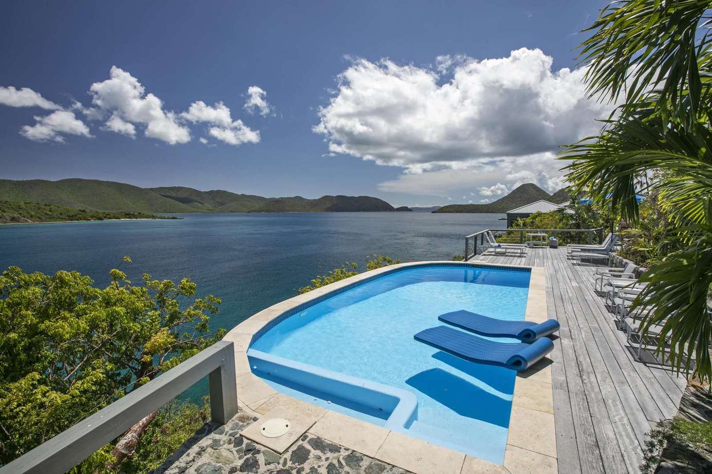 Infinity pool overlooking stunning ocean views and lush hills