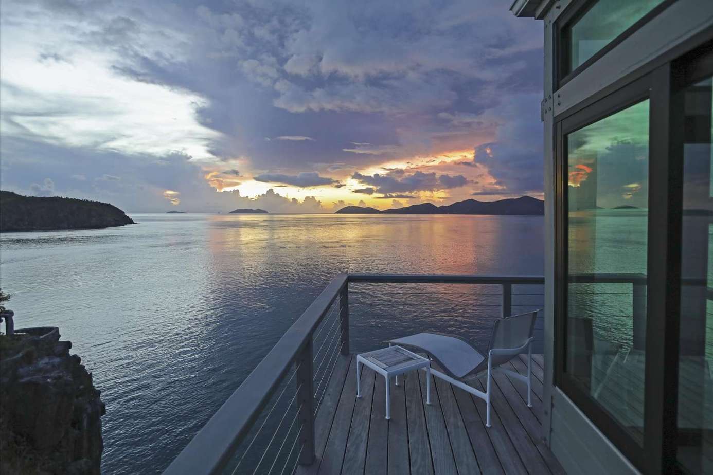Oceanfront balcony with stunning sunset views and cozy seating