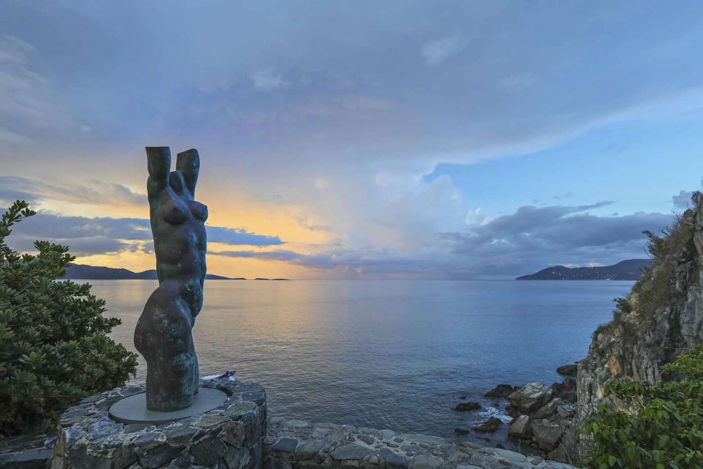 Serene oceanfront view with captivating sunset and sculpture