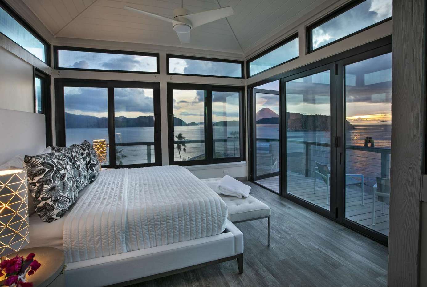 Sunlit bedroom with panoramic lake and mountain views