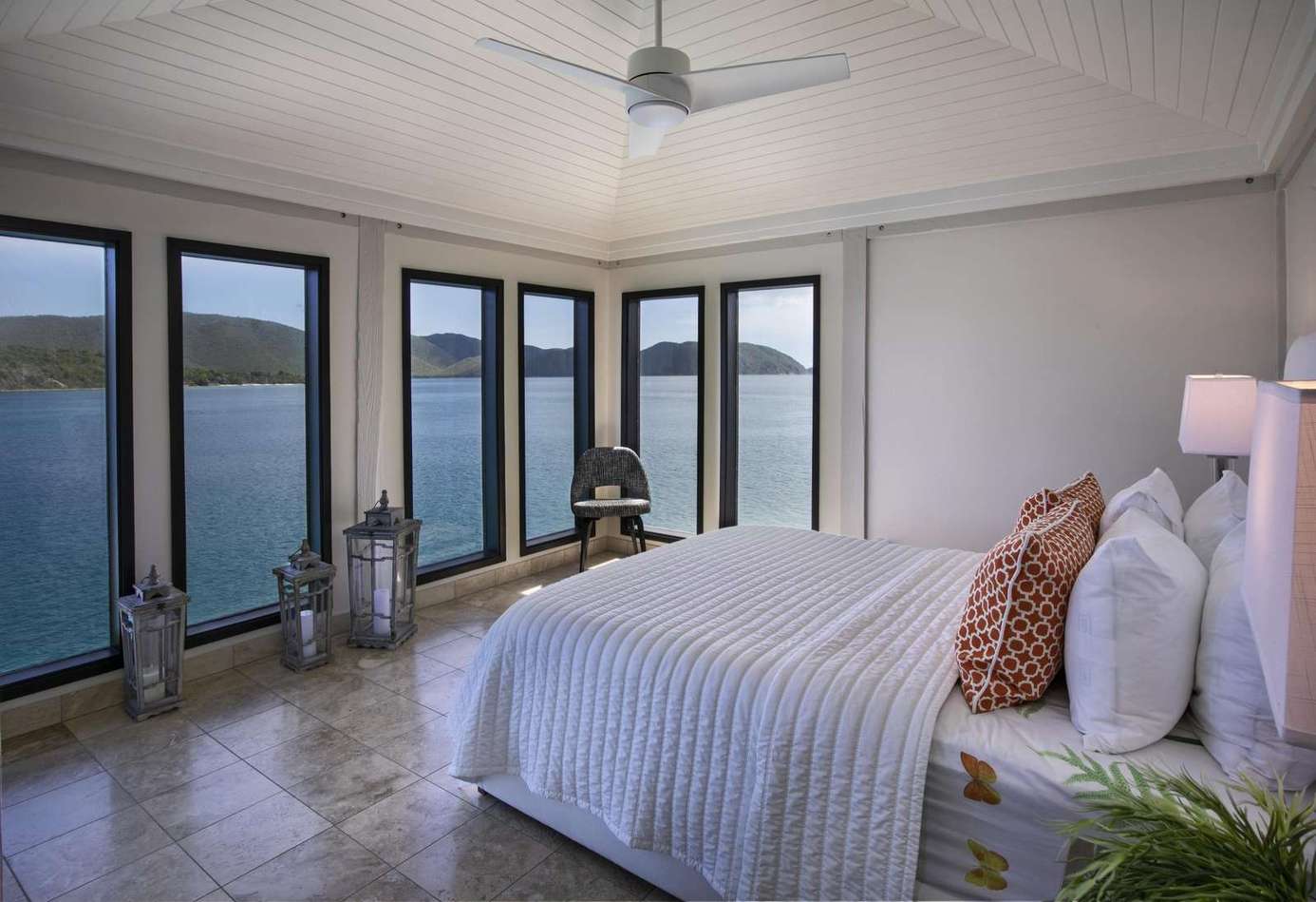 Serene bedroom with panoramic waterfront views and natural light