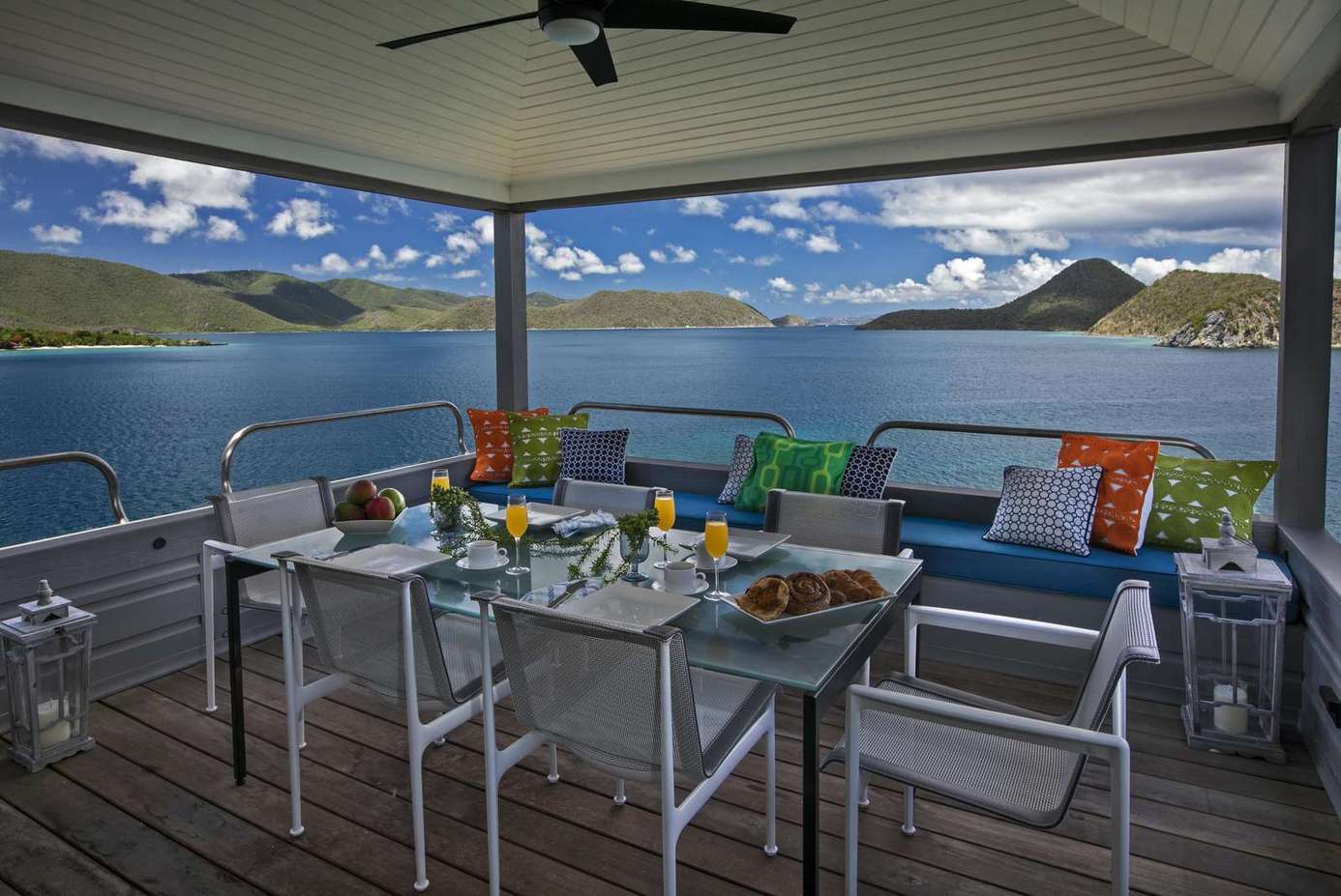 Spacious covered deck with panoramic waterfront views and dining area