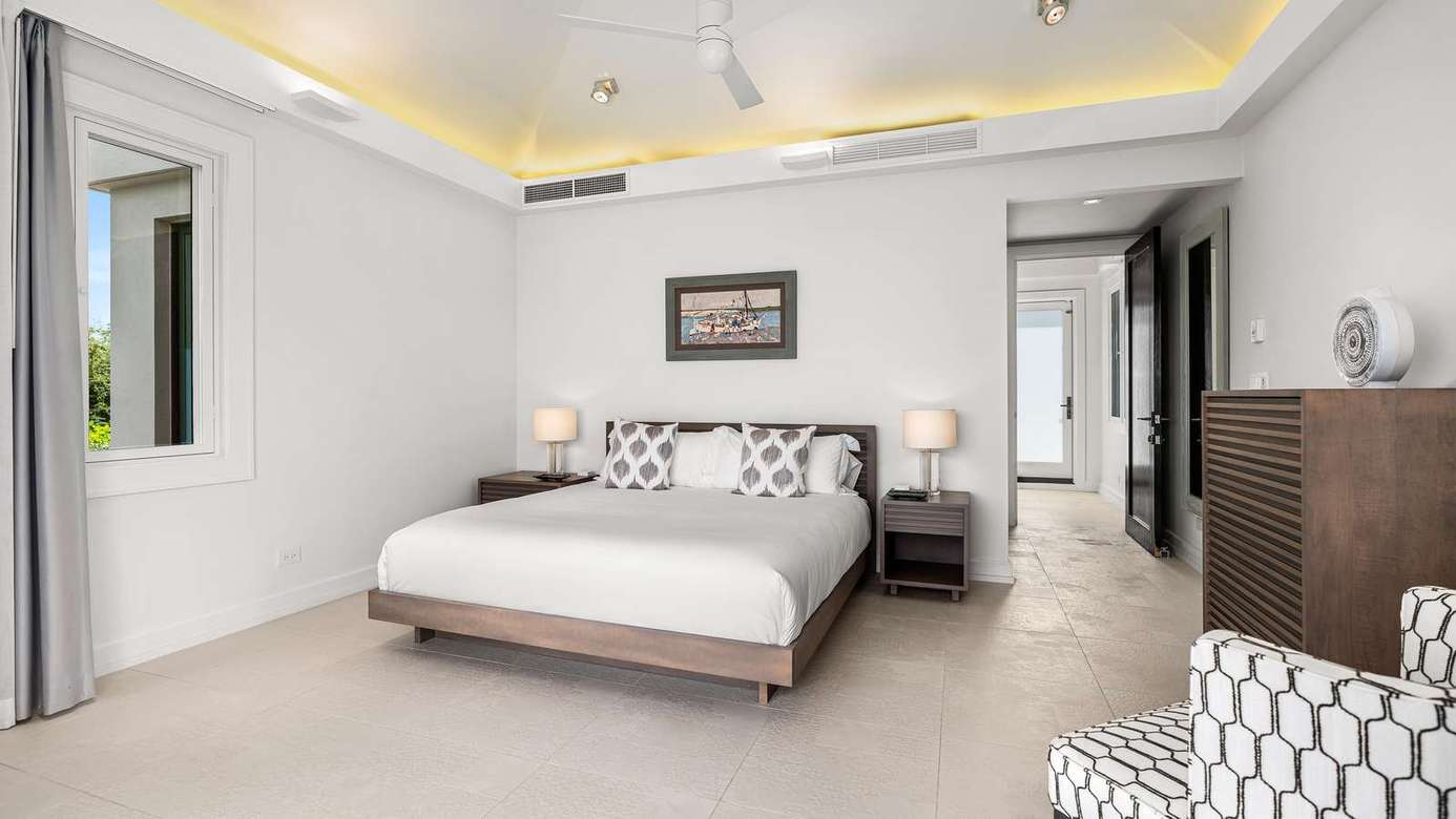Spacious master bedroom with elegant decor and cozy seating
