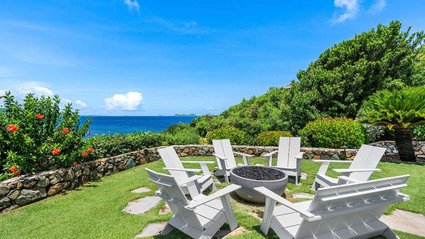 Ocean-view patio with cozy Adirondack seating and fire pit