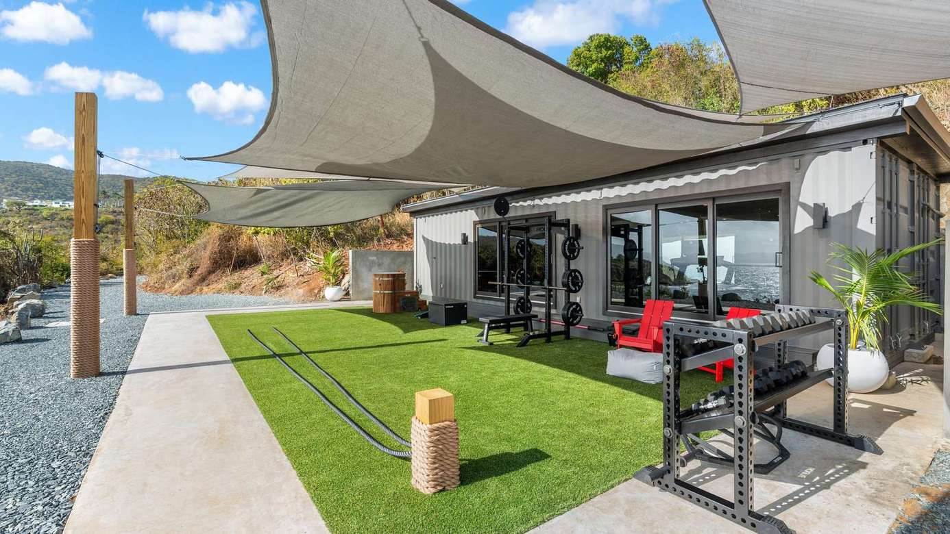 Sunlit patio with shaded lounge and scenic hillside views