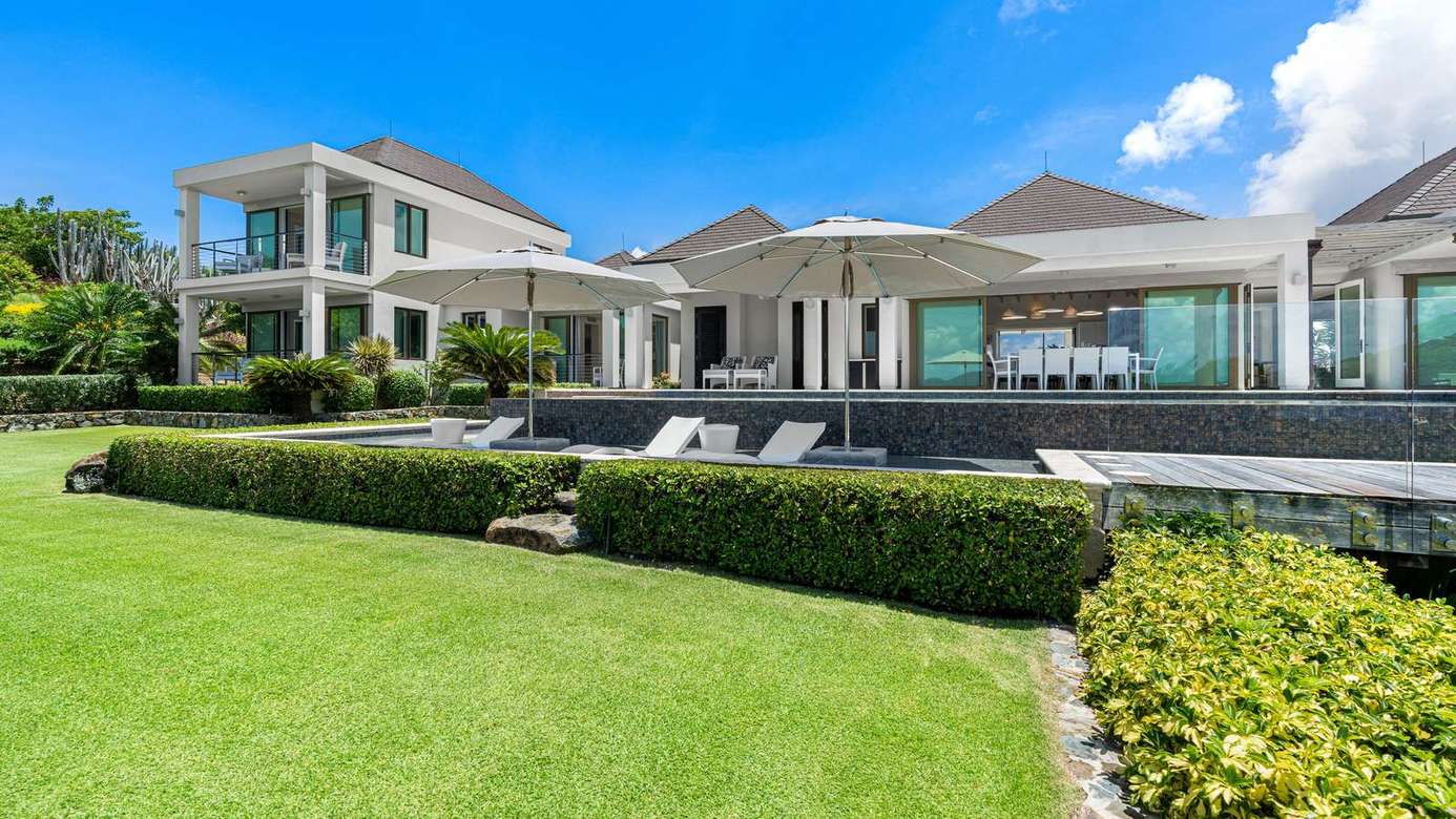 Expansive outdoor patio with pool and lush garden views
