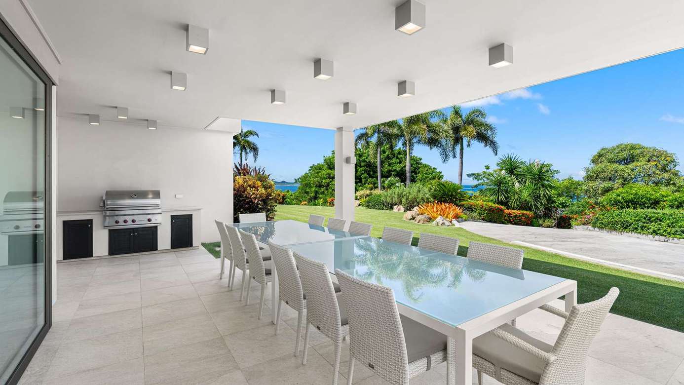 Spacious outdoor dining with built-in grill and garden views