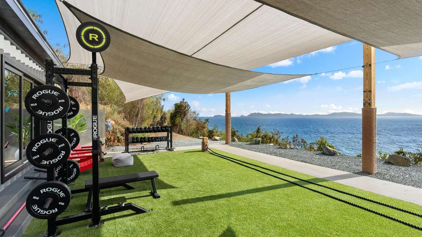 Sun-drenched patio with panoramic ocean views and shade sails